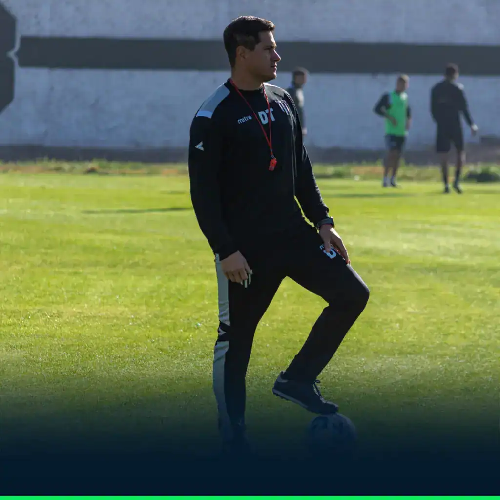 Entraîneur ou préparateur physique football supervisant une séance d'entraînement collectif sur terrain